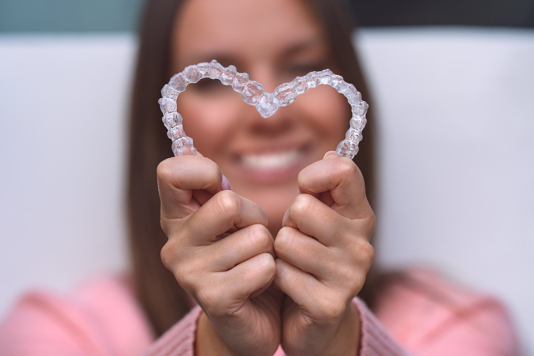 Woman with perfect smile after invisible invisalign aligners treatment